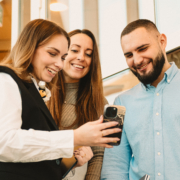 Sofia, Emma och Edin kollar på Sofias mobiltelefon