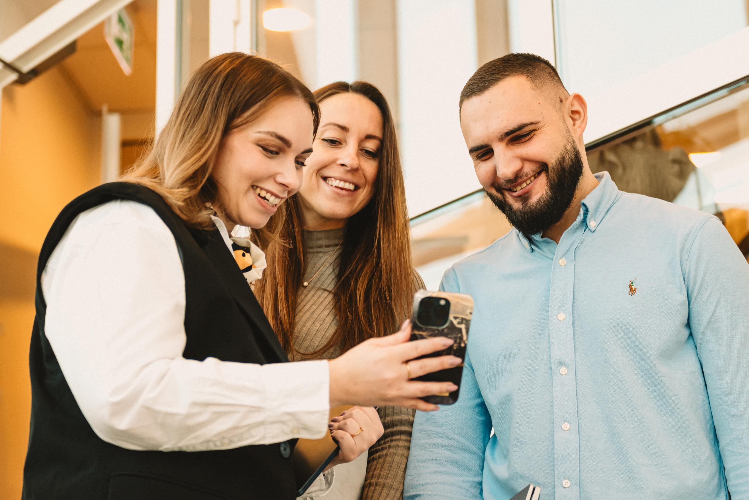 Sofia, Emma och Edin kollar på Sofias mobiltelefon