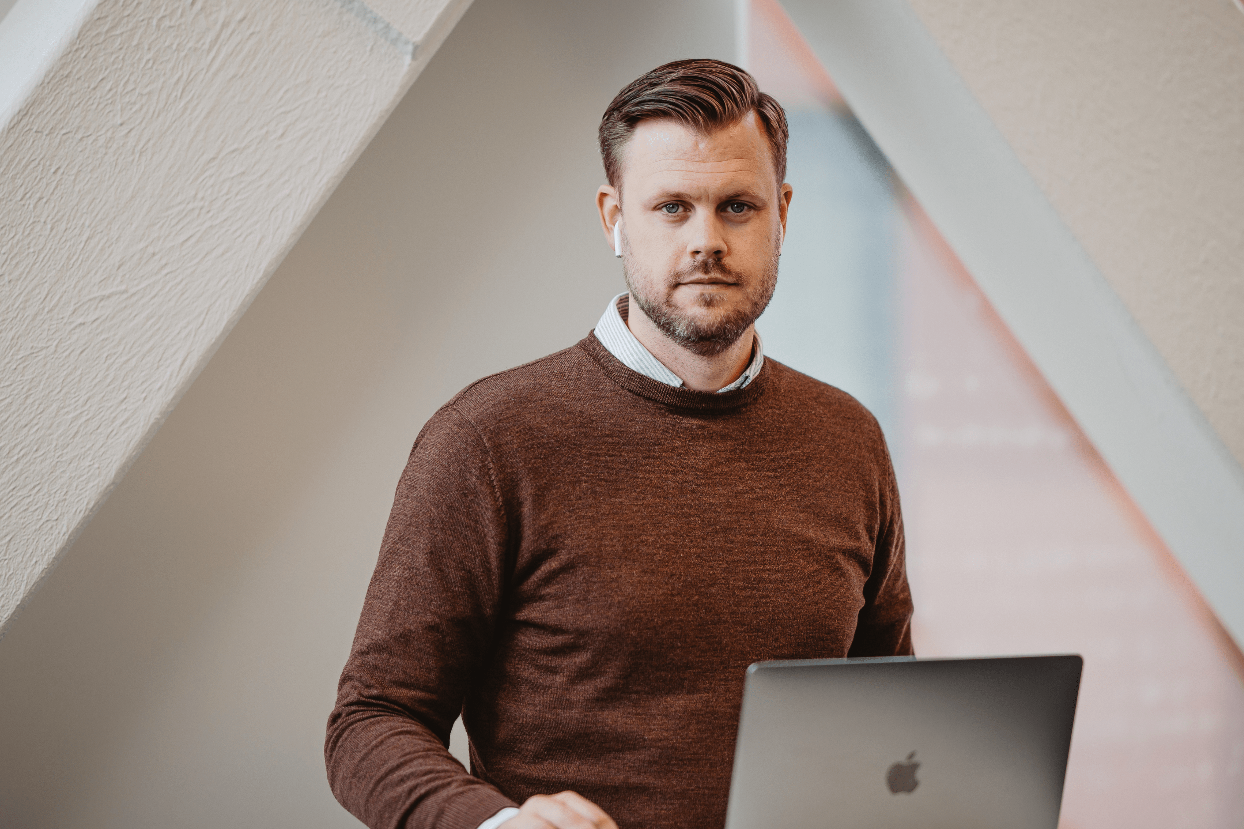 Jens står vid ett ståbord med sin laptop och ska prata om AI och hur det kan hjälpa företag att effektivisera